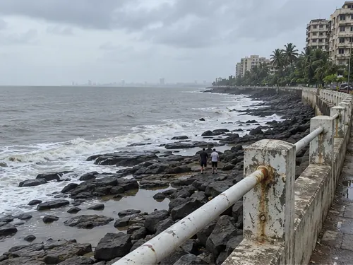 Black rocks and a worn sea wall at Bandstand in Bandra West on a grey afternoon