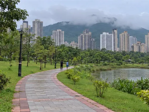 A walking path and lawns in the big park at Kharghar with towers beyond