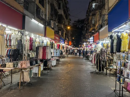 Small clothes shops and street stalls in the Lokhandwala market lane at night