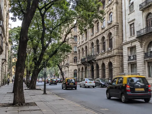 Old grey stone office buildings and taxis in the Fort area of south Mumbai